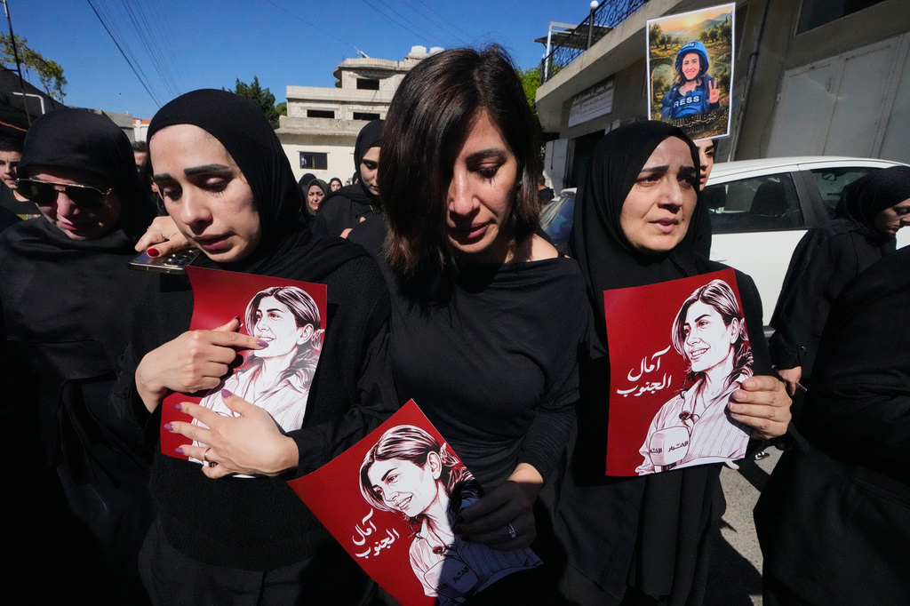 Mourners hold posters that show portraits of Lebanese journalist Amal Khalil, who was killed Wednesday in an Israeli airstrike, during her funeral procession in the village of Baysariyeh in southern Lebanon on Thursday, April 23, 2026. (AP Photo/Mohammed Zaatari)