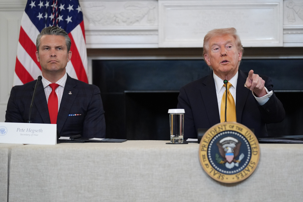 President Donald Trump answers questions from reporters during a roundtable on criminal cartels in the State Dining Room of the White House, Thursday, Oct. 23, 2025, in Washington, as Defense Secretary Pete Hegseth listen. (AP Photo/Evan Vucci)