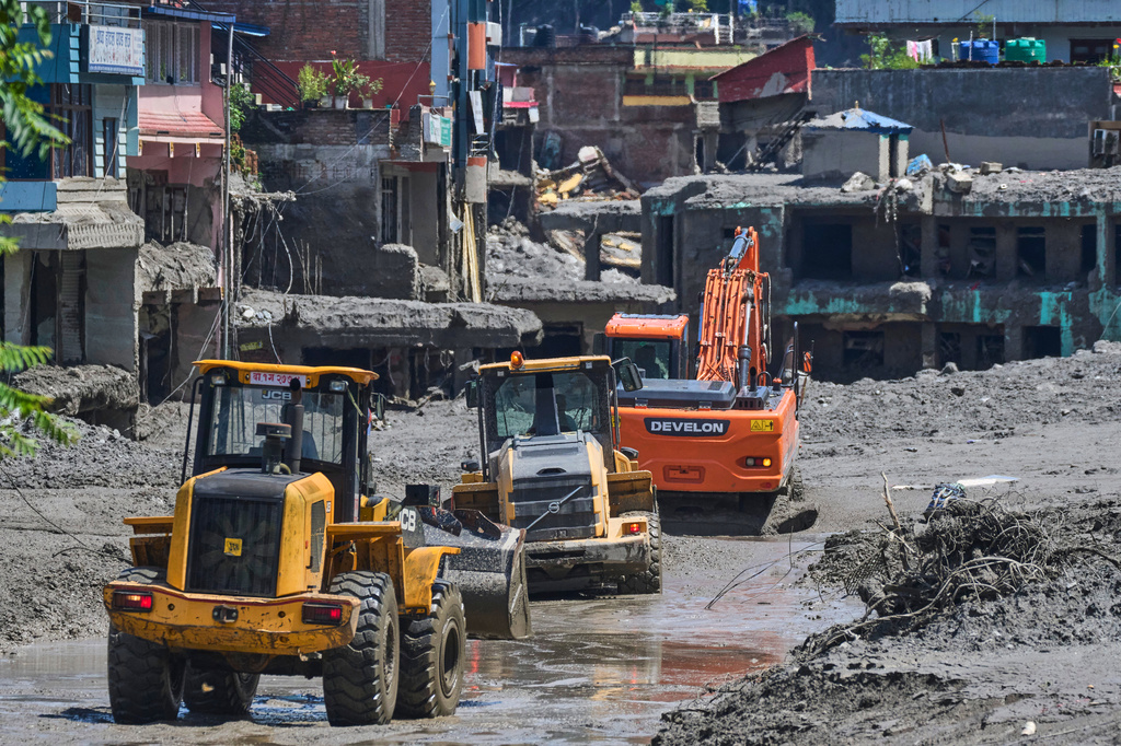 Earthmovers clear the debris of flash flooding in Nepal's Nuwakot district, Thursday, Aug. 27, 2026. (AP Photo/Niranjan Shrestha)