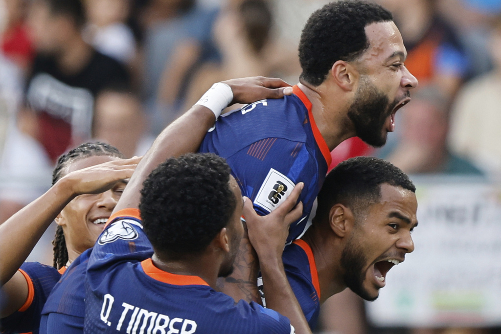 Dutch players celebrate their side's first goal scored by Memphis Depay, top, during the World Cup qualifying soccer match between Lithuania and Netherlands at Darius and Girenas stadium in Kaunas, Lithuania, Sunday, Sept. 7, 2025. (AP Photo/Mindaugas Kulbis)