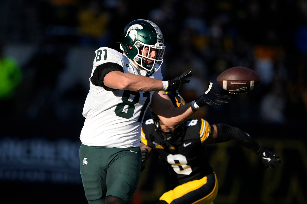 Michigan State tight end Michael Masunas (81) catches a pass in front of Iowa defensive back Deshaun Lee (8) during the first half of an NCAA college football game, Saturday, Nov. 22, 2025, in Iowa City, Iowa. (AP Photo/Charlie Neibergall)