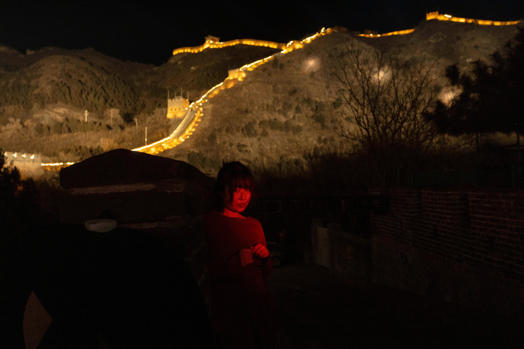 A woman stands for a photo by her friend before an event to ring in the new year at the Juyongguan Great Wall on the outskirts of Beijing, late Wednesday, Dec. 31, 2025. (AP Photo/Ng Han Guan)