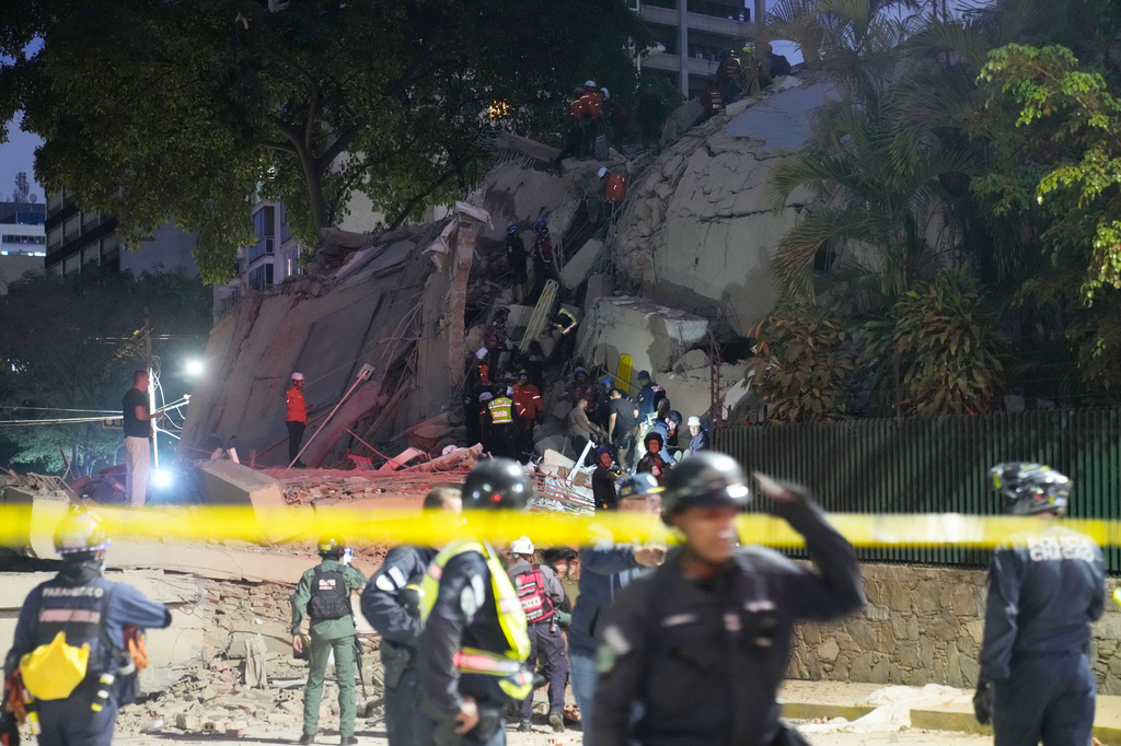 Rescue workers search for survivors at a collapsed building after an earthquake in Caracas, Venezuela, Wednesday, June 24, 2026. (AP Photo/Ariana Cubillos)