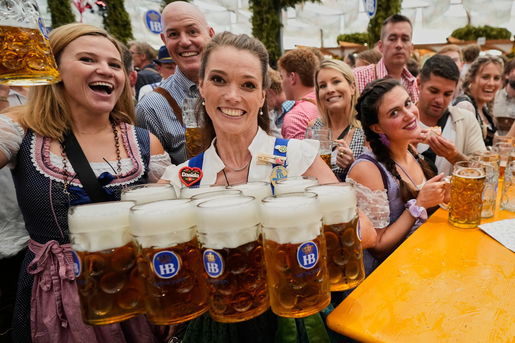 Waitress carriy beer mugs after the opening of the 191st Oktoberfest beer festival in Munich, Germany, Saturday, Sept.19, 2026. (AP Photo/Matthias Schrader)