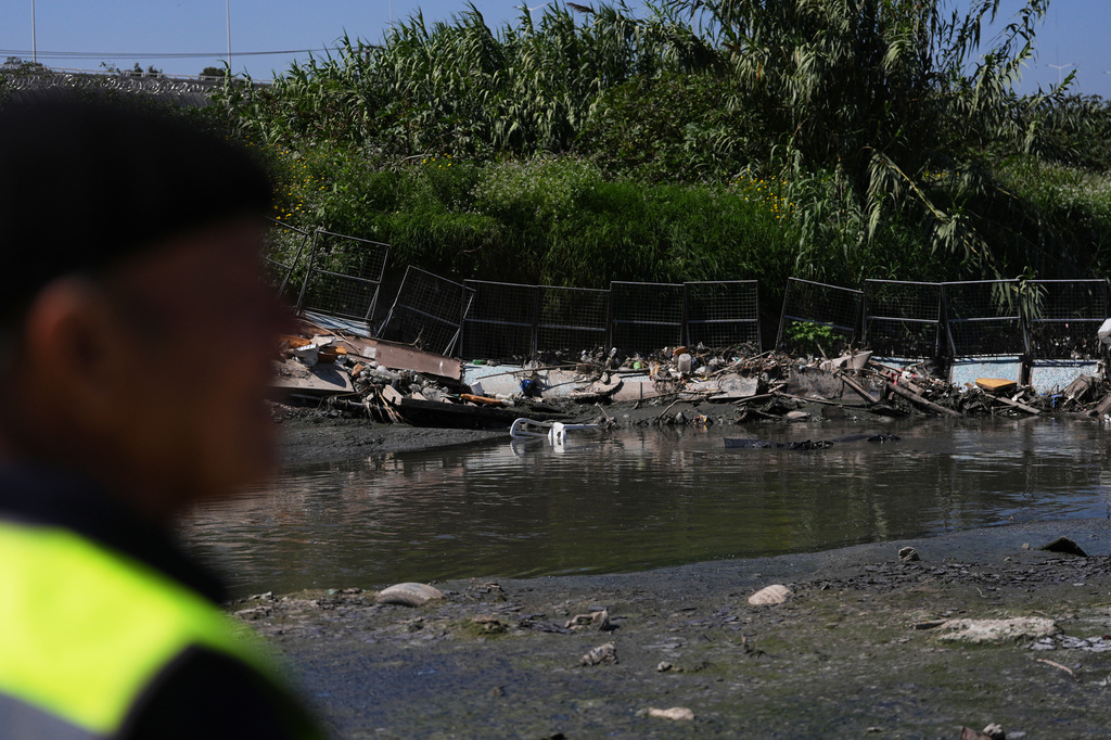Oscar Romo looks out over debris that has been captured by a trash boom installed in the Tijuana River at the border near where the river enters the United States from Tijuana, Mexico, Wednesday, April 8, 2026, in San Diego, Calif. (AP Photo/Gregory Bull)