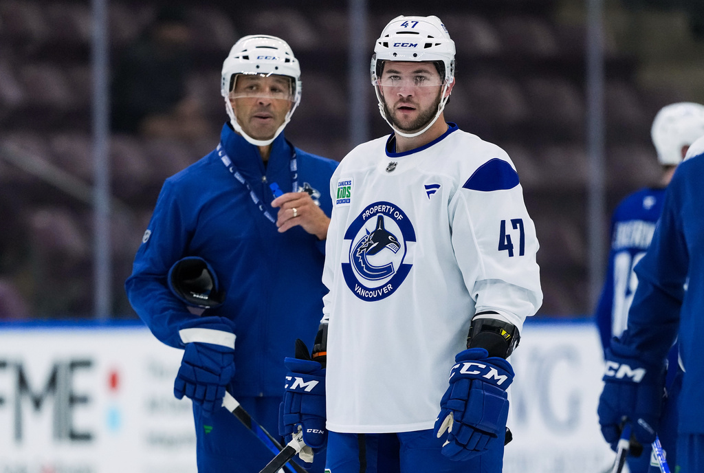Vancouver Canucks' Paul Cotter (47) and head coach Manny Malhotra, left, look on during opening day of the NHL hockey team's training camp in Penticton, British Columbia, Thursday, Sept. 17, 2026. (Darryl Dyck/The Canadian Press via AP)
