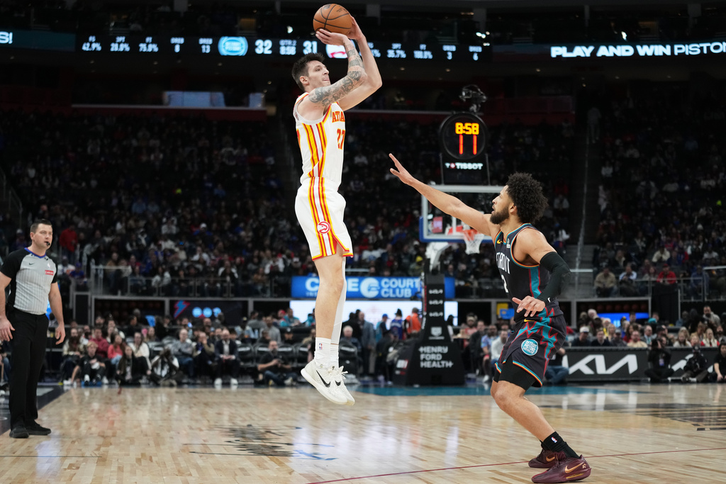 Atlanta Hawks guard Vit Krejci, left, shoots against Detroit Pistons guard Cade Cunningham during the first half of an NBA basketball game, Monday, Dec. 1, 2025, in Detroit. (AP Photo/Ryan Sun)