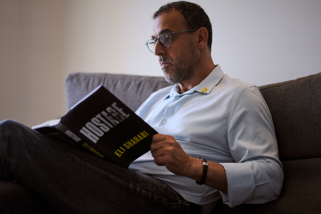 Eli Sharabi, who was abducted during the cross-border attack on Israel on Oct. 7, 2023, and held hostage by Hamas for 16 months, poses with his new book "Hostage" for a photo in Herzliya, Israel, Thursday, September 18, 2025. (AP Photo/Ariel Schalit)