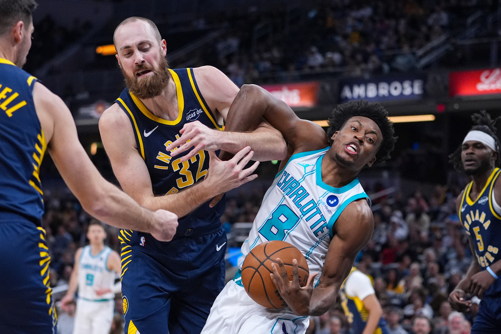 Indiana Pacers center Jay Huff (32) and Charlotte Hornets guard Collin Sexton (8) get tangled as they fight for a rebound during the first half of an NBA basketball game in Indianapolis, Wednesday, Nov. 19, 2025. (AP Photo/Michael Conroy)