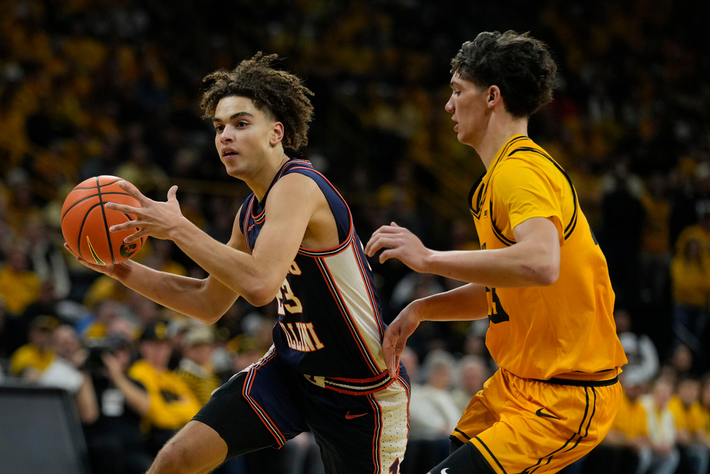 Illinois guard Keaton Wagler, left, drives past Iowa guard Isaia Howard during the first half of an NCAA college basketball game, Sunday, Jan. 11, 2026, in Iowa City, Iowa. (AP Photo/Charlie Neibergall)