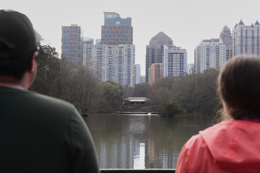 Fernando Coria and Sarah Woolson look at the skyline after screaming in Piedmont Park, Sunday, March 8, 2026, in Atlanta. (AP Photo/Emilie Megnien)