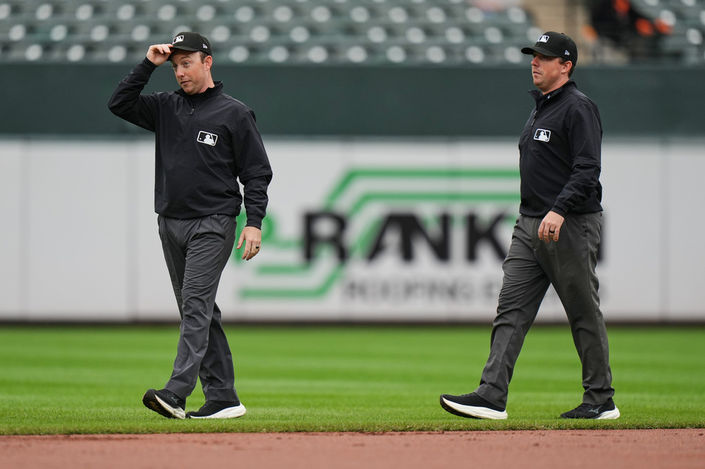Second base umpire Tyler Jones, left, and his twin brother first base umpire Austin Jones walk on the field during the second inning in the first baseball game of a doubleheader between the Baltimore Orioles and the Toronto Blue Jays, Wednesday, Sept. 23, 2026, in Baltimore. (AP Photo/Stephanie Scarbrough)