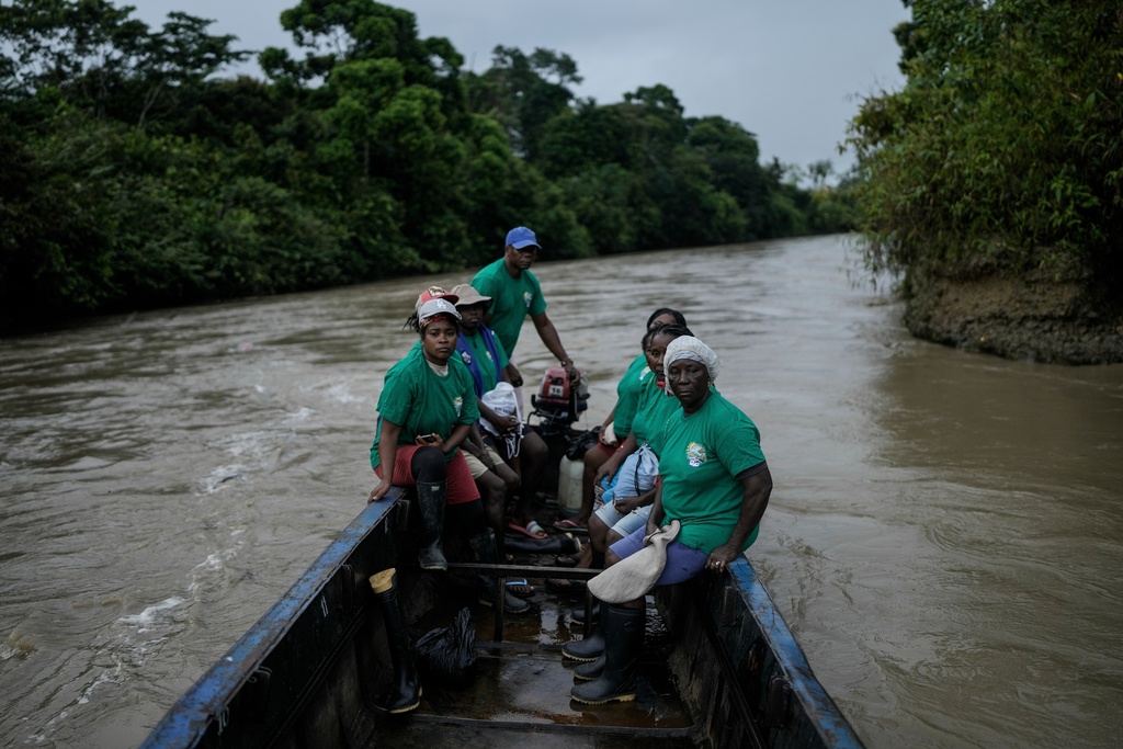 FILE - A group of women, part of Asociacion Nuestra Casa Comun, or Our Community House Association, go by boat to an area destroyed by illegal mining, on the Quito River, the Atrato River's main tributary, near Paimado, Colombia, Sept. 24, 2024. (AP Photo/Ivan Valencia, File)