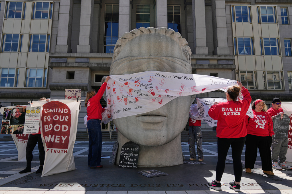People rally outside a courthouse while a hearing for Purdue Pharma takes place inside in Newark, N.J., Tuesday, April 21, 2026. (AP Photo/Seth Wenig)