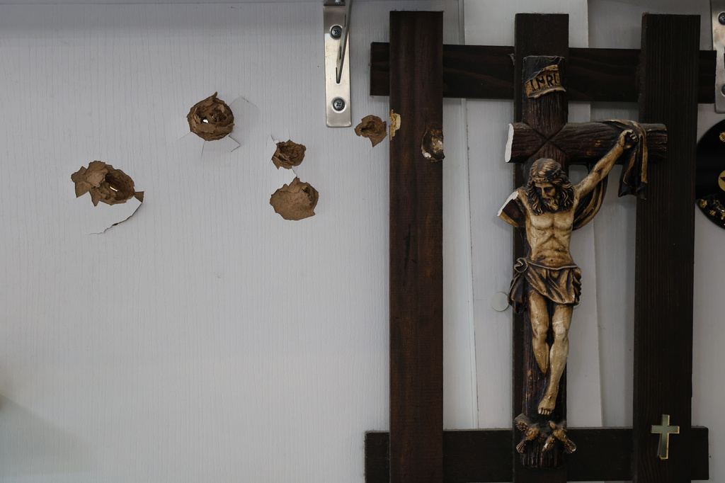 Bullet holes mark a wall next to a crucifix following overnight violence in the predominantly Christian town of Al-Suqaylabiyah, west of Hama, Syria, Saturday, March 28, 2026. (AP Photo/Omar Albam)