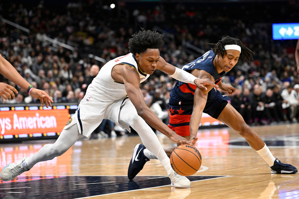 Denver Nuggets guard Peyton Watson, left, and Washington Wizards guard Tre Johnson compete for a loose ball during the second half of an NBA basketball game, Thursday, Jan. 22, 2026, in Washington. (AP Photo/John McDonnell)