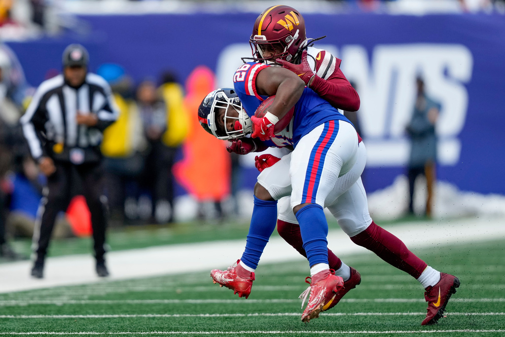 New York Giants running back Devin Singletary (26) is tackled by Washington Commanders outside linebacker Von Miller (24) during the second quarter of an NFL football game, Sunday, Dec. 14, 2025, in East Rutherford, N.J. (AP Photo/Yuki Iwamura)