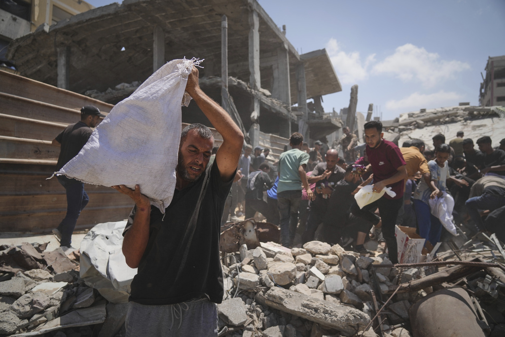 Palestinians struggle to collect humanitarian aid airdropped by parachutes into Gaza City, northern Gaza Strip, Thursday, Aug. 7, 2025. (AP Photo/Jehad Alshrafi)