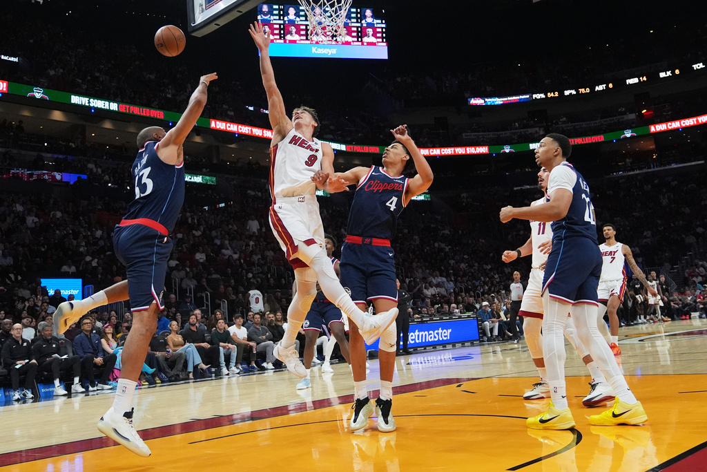 Miami Heat guard Pelle Larsson (9) goes to the basket as Los Angeles Clippers forward Nicolas Batum (33) defends during the first half of an NBA basketball game, Monday, Dec. 1, 2025, in Miami. (AP Photo/Lynne Sladky)