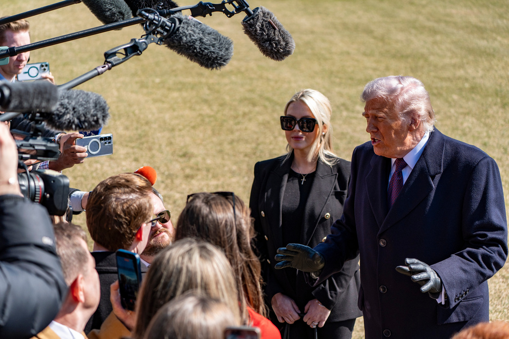 President Donald Trump, accompanied by White House press secretary Karoline Leavitt, speaks to reporters before departing on Marine One from the South Lawn of the White House, Friday, Feb. 27, 2026, in Washington. (AP Photo/Alex Brandon)