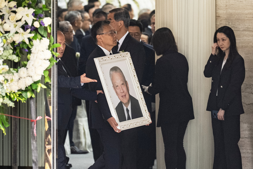 Andy Tung, son of former Hong Kong leader Tung Chee-hwa, carries his father's portrait at a funeral home in Hong Kong, Sunday, Sept. 20, 2026. (AP Photo/Chan Long Hei)