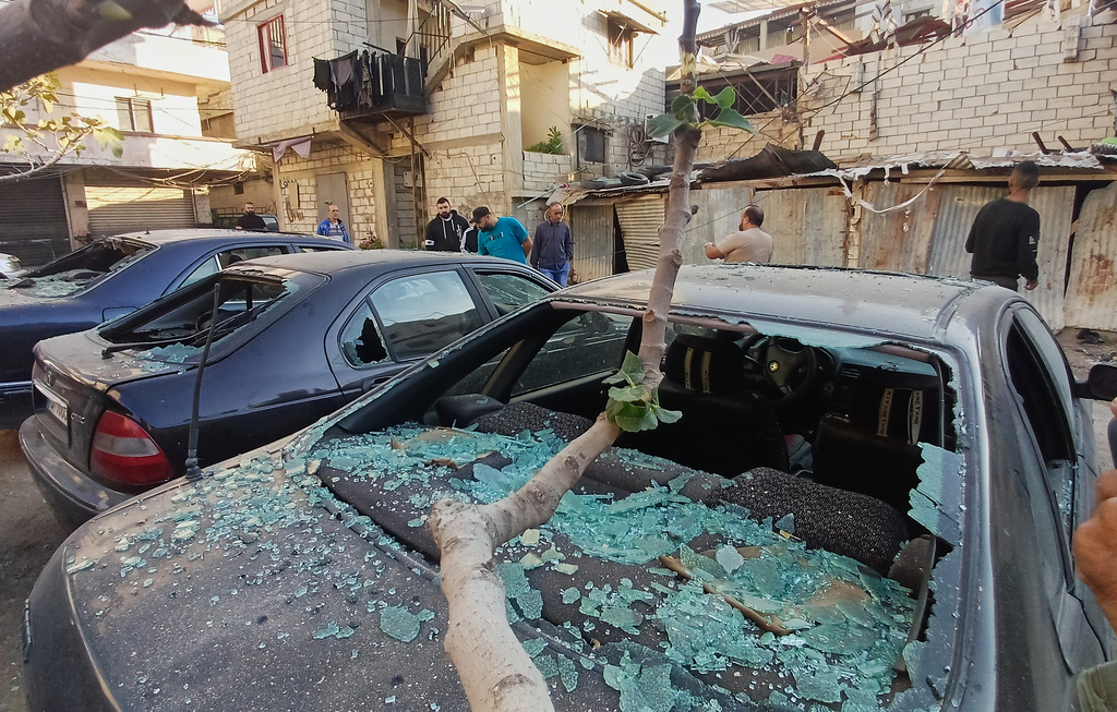 Palestinian people check cars that were damaged by an Israeli strike that hit on Tuesday night in the Ein el-Hilweh Palestinian refugee camp, in the southern port city of Sidon, Lebanon, Wednesday, Nov. 19, 2025. (AP Photo/Mohammed Zaatari)
