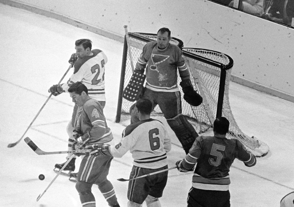 FILE - St. Louis Blues goalie Glenn Hall, top right, is pinned to his net waiting to make a save on a Montreal Canadians shot as Blues' Noel Picard (4) tries to block the puck while Canadiens' John Ferguson (22) and Ralph Backstorm wait for a rebound in the third period of their NHL hockey Stanley Cup game, May 5, 1968. (AP Photo/Fred Waters, File)