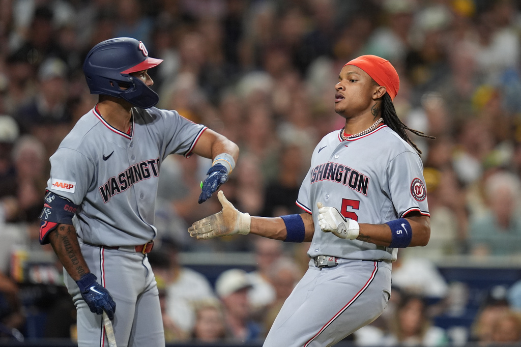 Washington Nationals' CJ Abrams, right, celebrates with teammate Daylen Lile after scoring on a two-RBI double by Brady House during the sixth inning of a baseball game Tuesday, Sept. 8, 2026, in San Diego. (AP Photo/Gregory Bull)