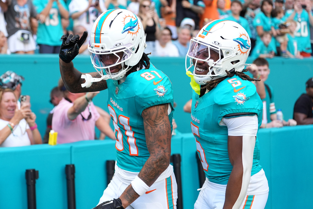 Miami Dolphins wide receiver Theo Wease Jr. (81) celebrates with running back Jaylen Wright (5) after scoring a touchdown against the Tampa Bay Buccaneers during the first half of an NFL football game Sunday, Dec. 28, 2025, in Miami Gardens, Fla. (AP Photo/Rebecca Blackwell)