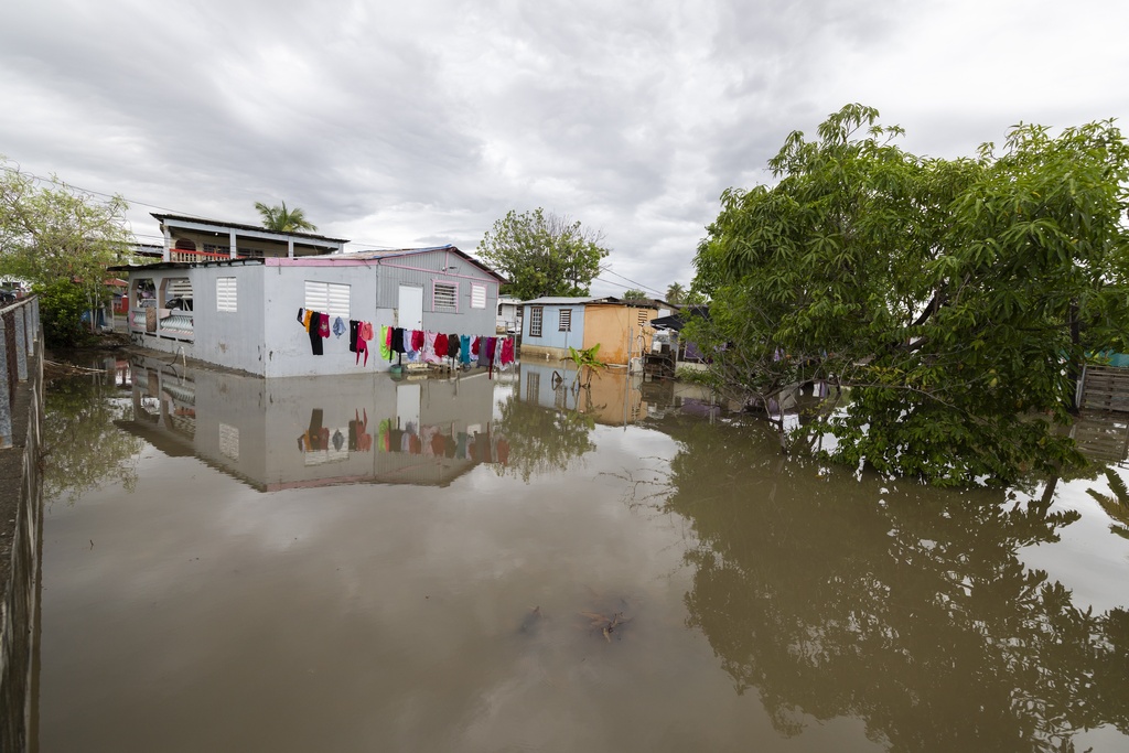 Water surrounds a house in Guayama, Puerto Rico, as Hurricane Erin brings rains to the island, Sunday, Aug. 17, 2025. (AP Photo/Alejandro Granadillo)