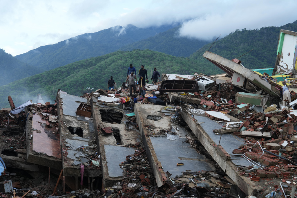 Residents search through the rubble of a building that collapsed in the earthquakes in La Guaira, Venezuela, Tuesday, June 30, 2026. (AP Photo/Ariana Cubillos)