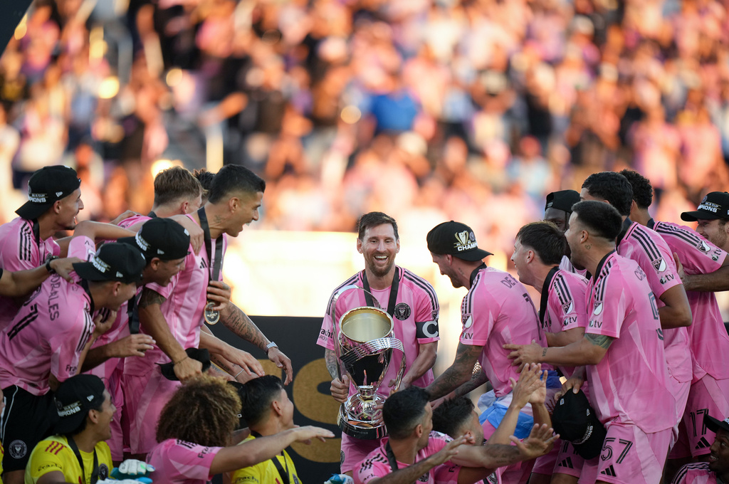 Inter Miami's Lionel Messi, centre, carries the trophy to celebrate with his teammates after defeating the Vancouver Whitecaps during the MLS Cup final soccer match, in Fort Lauderdale, Fla., Saturday, Dec. 6, 2025. (Darryl Dyck/The Canadian Press via AP)