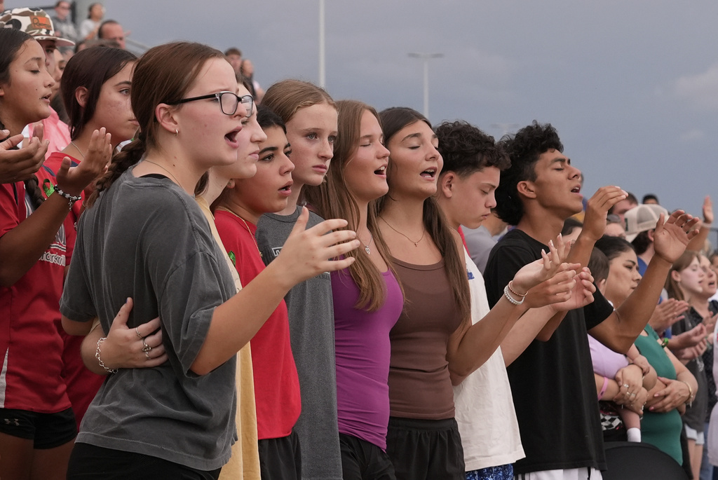 Attendees sing during a vigil for flooding victims at Tivy Antler Stadium on Wednesday, July 9, 2025, in Kerrville, Texas. (AP Photo/Gerald Herbert)