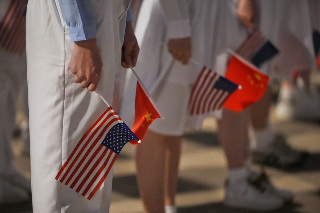 People hold American and Chinese flags for a welcome ceremony as President Donald Trump arrives on Air Force One, Wednesday, May 13, 2026, at Beijing Capital International Airport in Beijing. (AP Photo/Mark Schiefelbein)