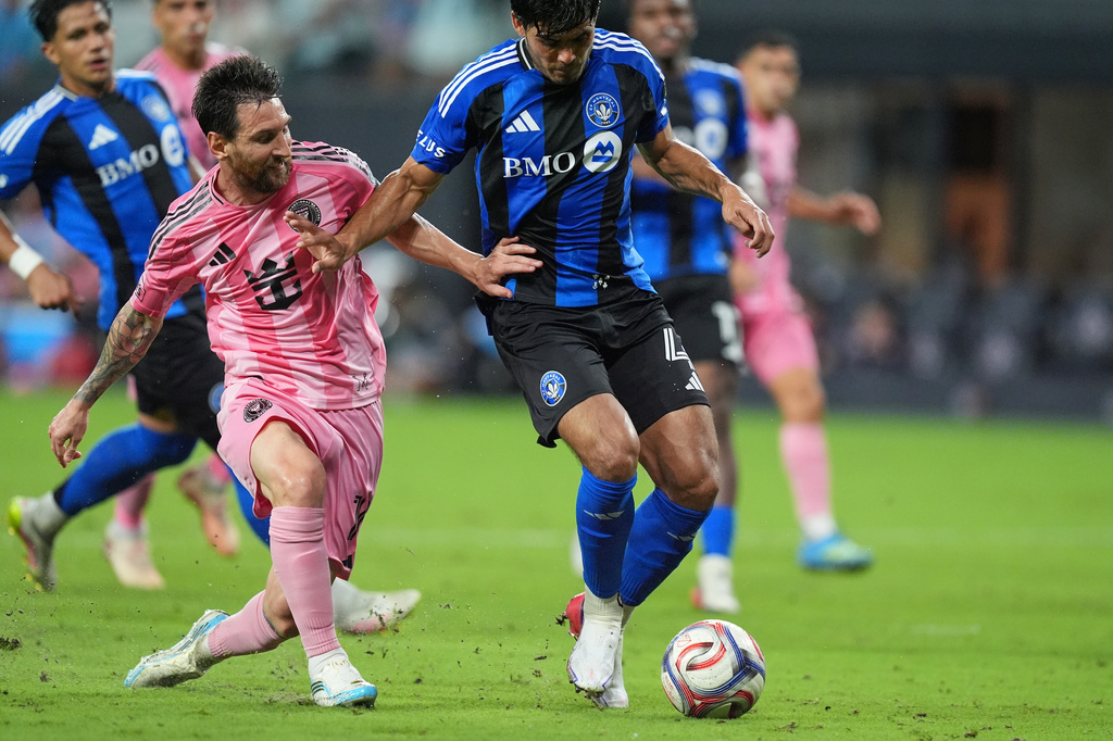 Inter Miami forward Lionel Messi, left, battles with CF Montreal defender Brayan Vera (4) during the second half of an MLS soccer match, Saturday, Aug. 29, 2026, in Miami. (AP Photo/Rebecca Blackwell)