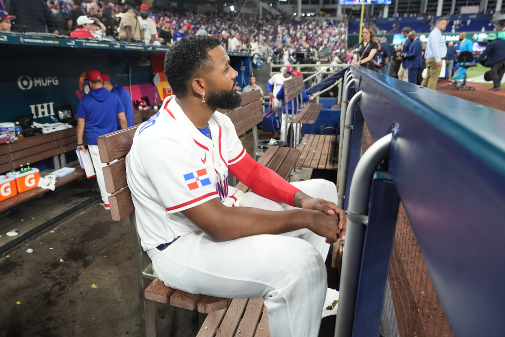 Dominican Republic third baseman Junior Caminero sits in the dugout at the end of a World Baseball Classic semifinal game against the United States, Sunday, March 15, 2026, in Miami. (AP Photo/Lynne Sladky)