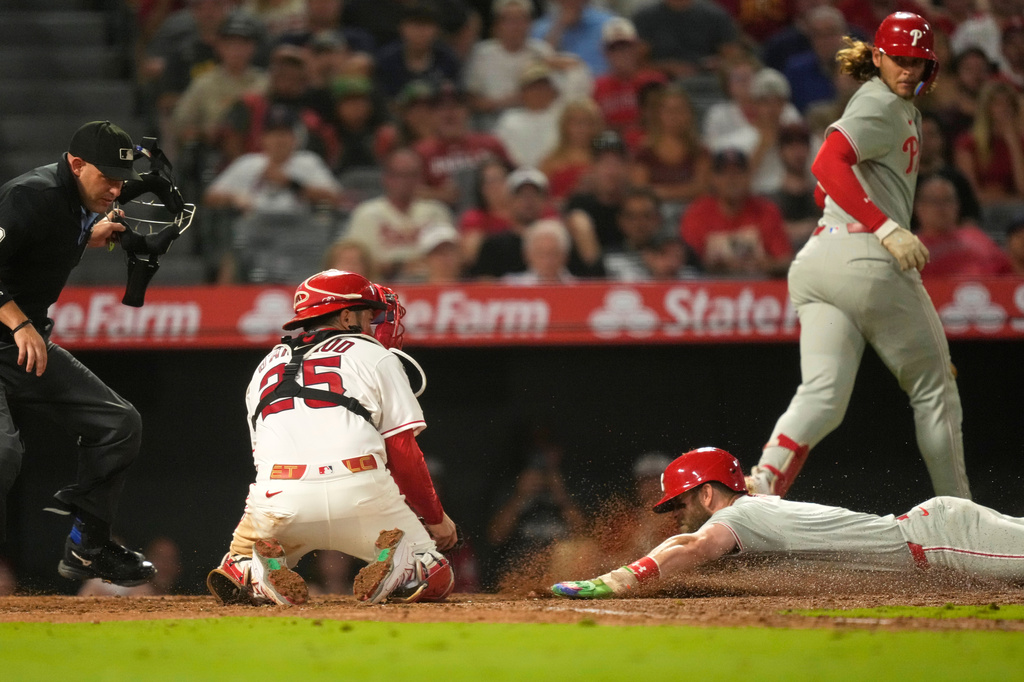 Philadelphia Phillies' Bryce Harper, lower right, is tagged out by Los Angeles Angels catcher Travis D'Arnaud, second from left, as he tries to steal home as home plate umpire Dan Merzel and Alec Bohm watch during the eighth inning of a baseball game Saturday, Aug. 29, 2026, in Anaheim, Calif. (AP Photo/Mark J. Terrill)