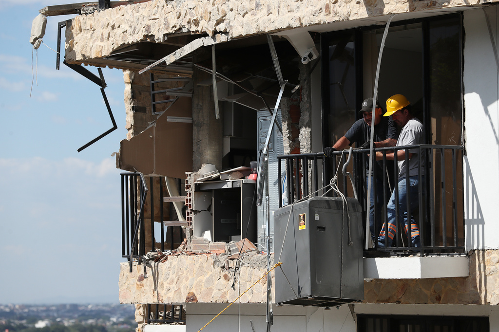 People remove a washing machine from an earthquake-damaged home three days after a quake hit Cali, Colombia, Thursday, Aug. 13, 2026. (AP Photo/Santiago Saldarriaga)