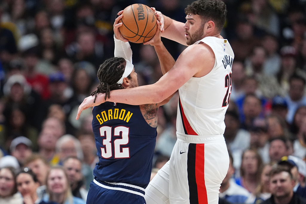 Portland Trail Blazers center Donovan Clingan, right, ties up Denver Nuggets forward Aaron Gordon as he drives to the rim in the first half of an NBA basketball game Monday, April 6, 2026, in Denver. (AP Photo/David Zalubowski)