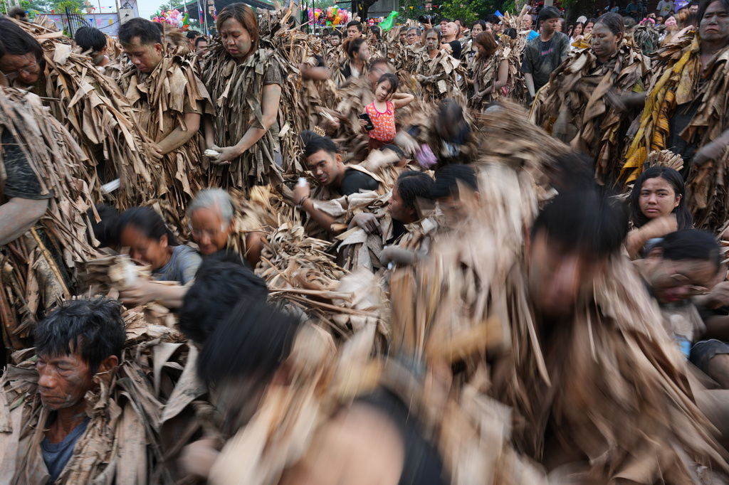 Catholic devotee covered in mud and dried banana leaves participate at the mud people festival on the feast day of Saint John the Baptist at Bibiclat, Nueva Ecija province, northern Philippines on Wednesday, June 24, 2026. (AP Photo/Aaron Favila)
