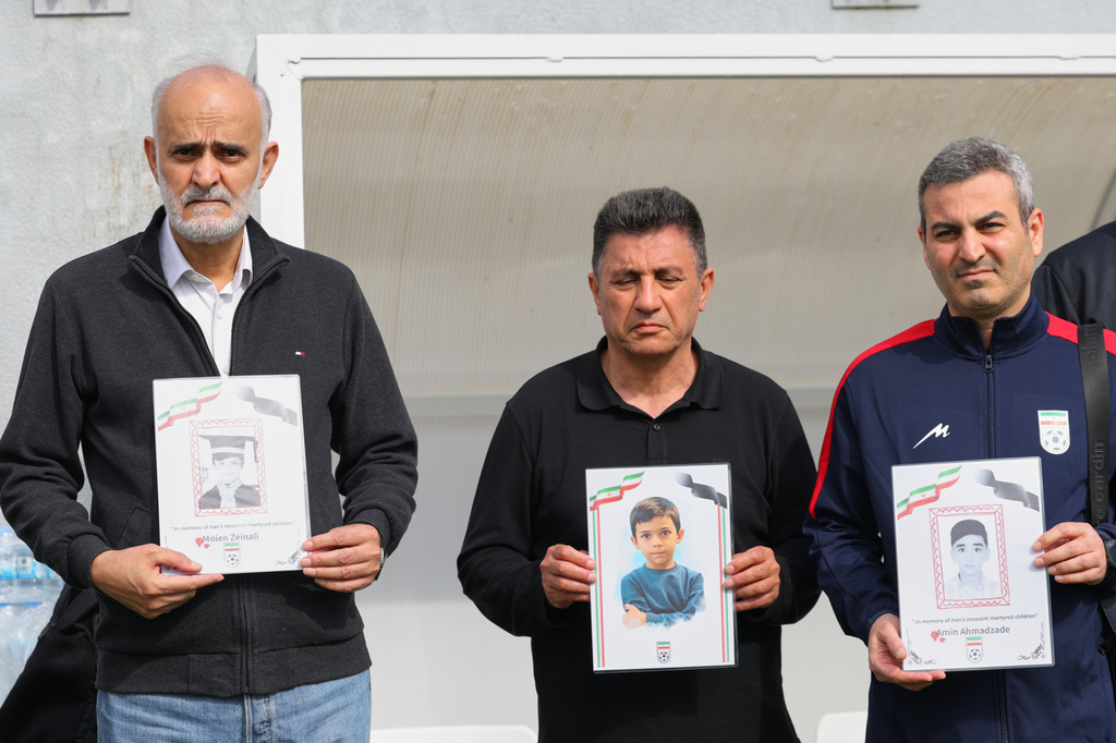 FILE - Iran's coach Amir Ghalenoei, center, and Iran's Football Federation Vice President Mehdi Mohammad Nabi, left, hold pictures of children allegedly killed in a U.S. and Israel strikes in Iran, before an international friendly soccer match between Iran and Costa Rica, in Antalya, southern Turkey, Tuesday, March 31, 2026. (AP Photo/Riza Ozel, File)