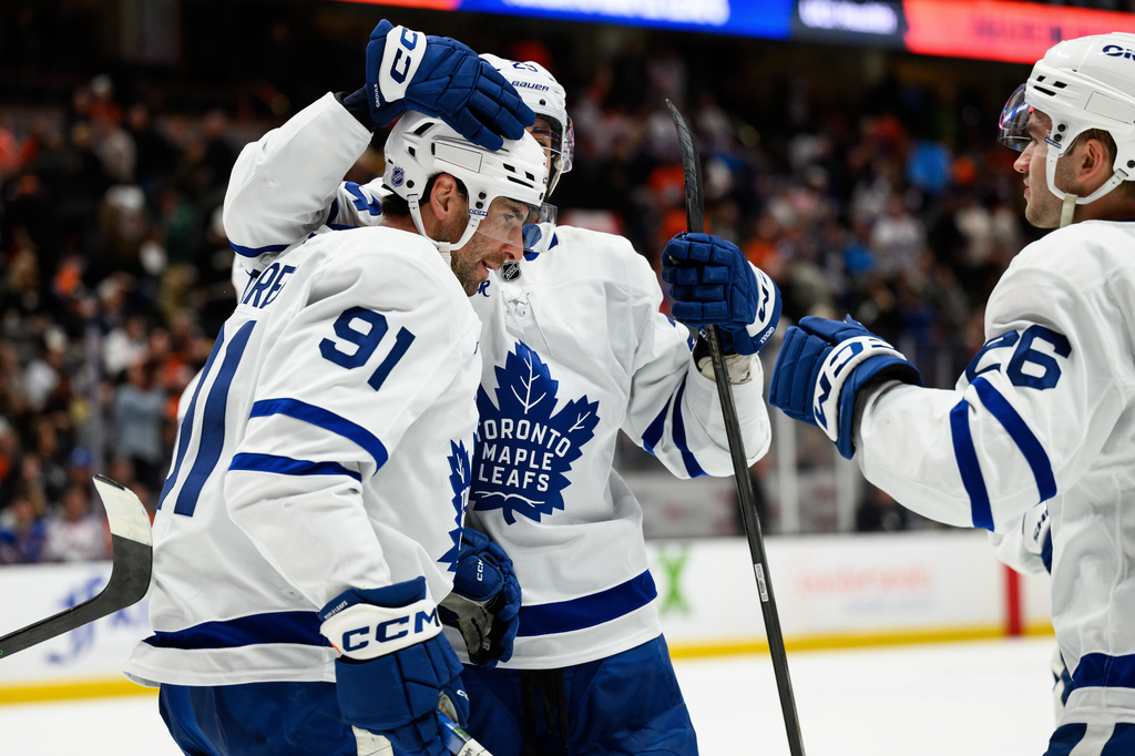 Toronto Maple Leafs center John Tavares (91) is greeted by teammates after scoring the game-winning goal during overtime of an NHL hockey game against the Anaheim Ducks, Monday, March 30, 2026, in Anaheim, Calif. (AP Photo/William Liang)