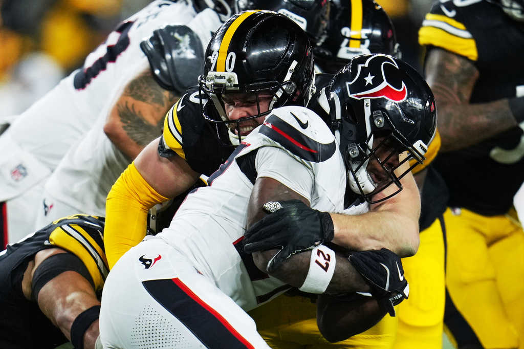 FILE - Houston Texans running back Woody Marks (27) is tackled by Pittsburgh Steelers linebacker T.J. Watt (90) during the first half of NFL wild-card playoff football game, Jan. 12, 2026, in Pittsburgh. (AP Photo/Gene J. Puskar, File)