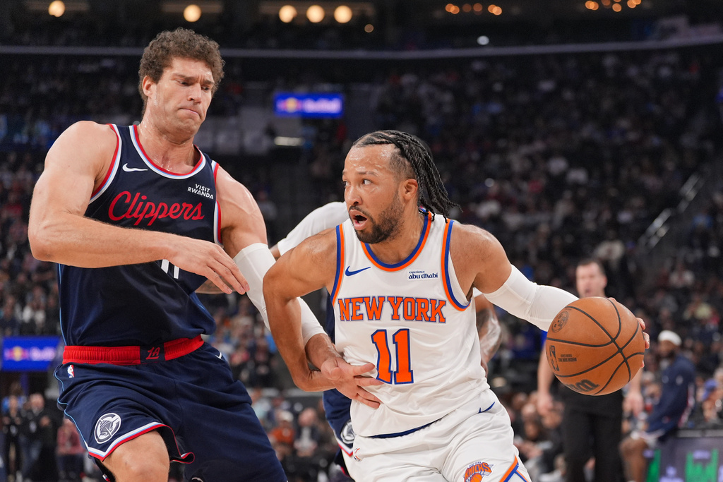 New York Knicks guard Jalen Brunson, right, works around Los Angeles Clippers center Brook Lopez during the first half of an NBA basketball game Monday, March 9, 2026, in Inglewood, Calif. (AP Photo/Jae C. Hong)