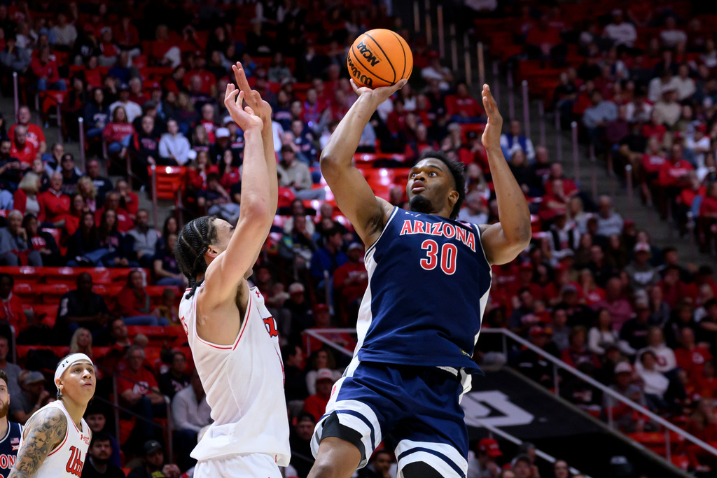 Arizona forward Tobe Awaka, right, shoots over Utah forward Keanu Dawes, left, during the second half of an NCAA college basketball game, Saturday, Jan. 3, 2026, in Salt Lake City. (AP Photo/Tyler Tate)