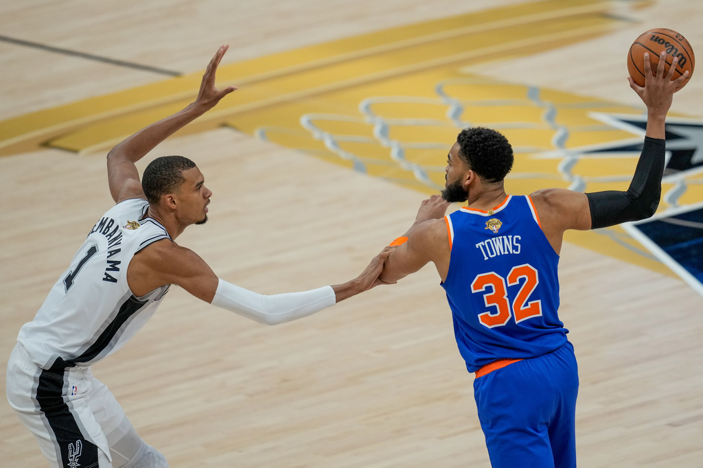San Antonio Spurs forward Victor Wembanyama (1) defends against New York Knicks center Karl-Anthony Towns (32) during the first half of Game 2 of the NBA Finals basketball series, Friday, June 5, 2026, in San Antonio. (AP Photo/David J. Phillip)