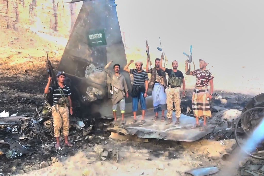This image from an undated video released Wednesday, Sept. 16, 2026, by the Ansar Allah Media Office, the media arm of Yemen's Houthi rebels, shows Houthi fighters posing and chanting atop what the group described as the wreckage of a downed Saudi F-15 fighter jet bearing a Saudi flag in Marib province, Yemen. (Ansar Allah Media Office via AP)