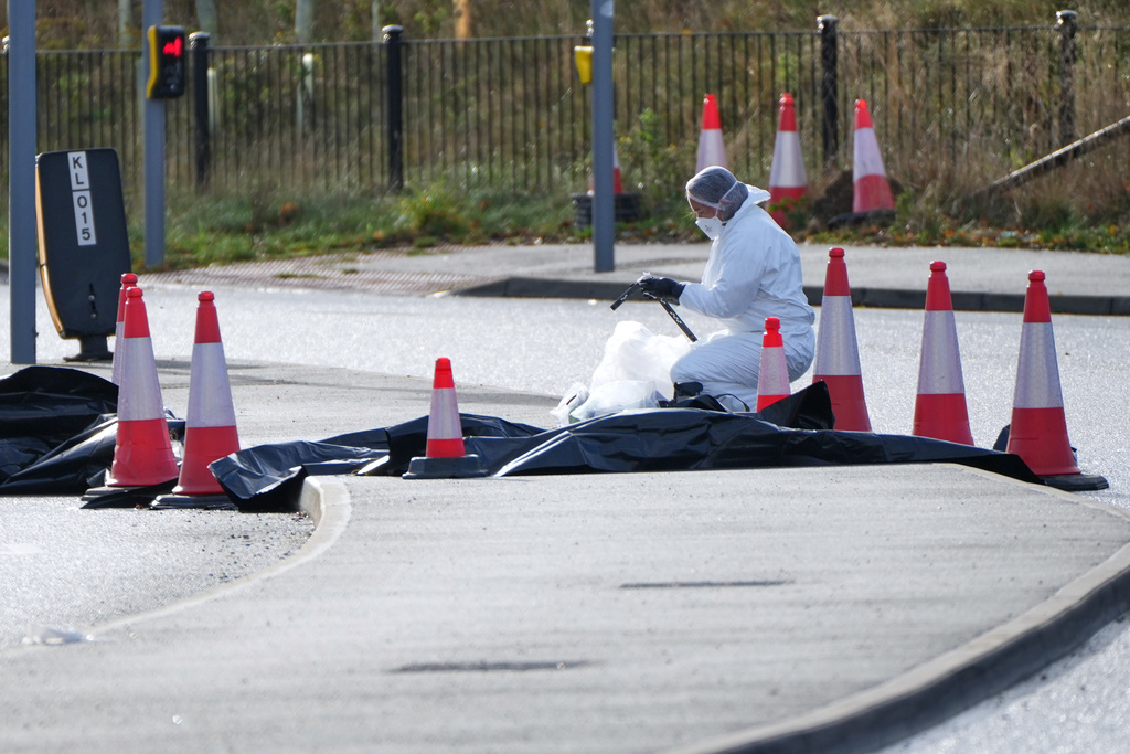 A forensic investigator works on a road leading to a train station after a mass stabbing on a London-bound train in Huntingdon, England, Sunday, Nov. 2, 2025.(AP Photo/Kirsty Wigglesworth)
