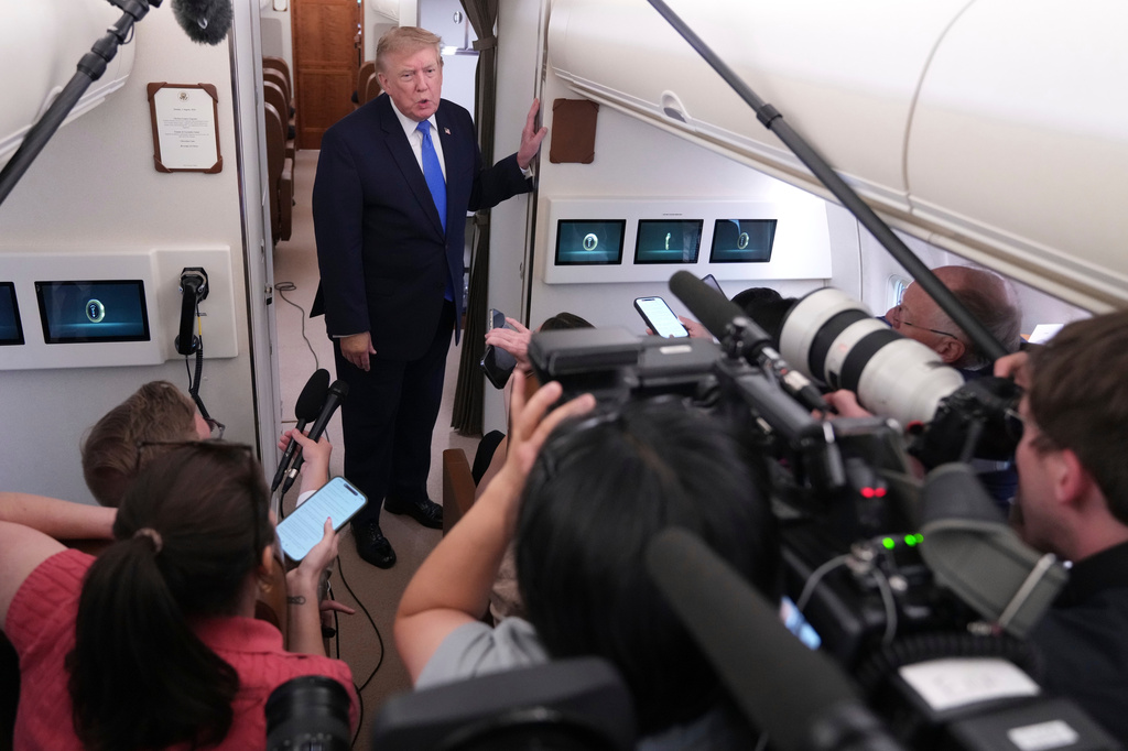 President Donald Trump speaks to reporters onboard Air Force One while returning to the White House, Sunday, Aug. 2, 2026. (AP Photo/Jacquelyn Martin)