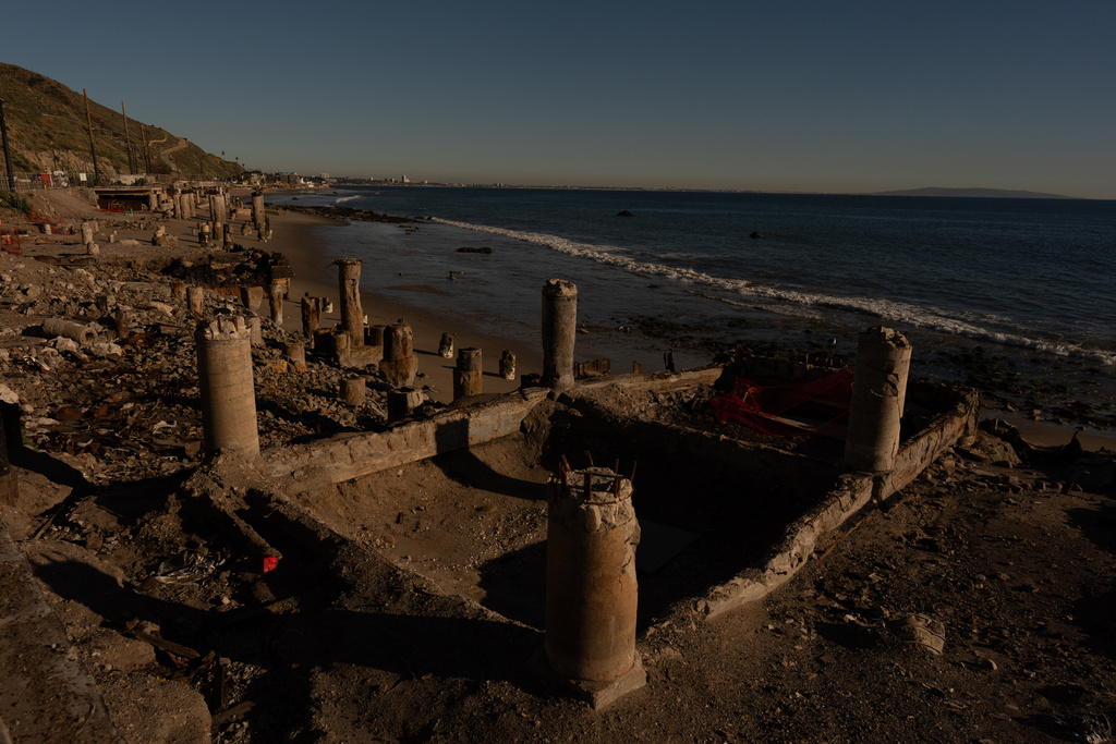 The remains of an oceanfront home that burned in the Palisades Fire, Friday, Dec. 5, 2025, sits on the shore of Malibu, Calif. (AP Photo/Jae C. Hong)
